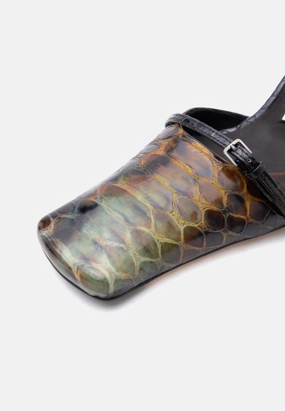 Παντόφλα με τετράγωνη μύτη, γυαλιστερό καφέ και πράσινο σχέδιο δέρματος φιδιού και λεπτό μαύρο λουράκι με ασημένια αγκράφα στο πάνω μέρος.