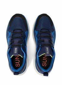 Tummansinisiä urheilujalkineita, joissa on verkko- ja synteettinen päällinen, mustat yksityiskohdat, heijastavat yksityiskohdat ja pehmustetut pohjat. Mukana nauhat ja pehmustettu kaulus.