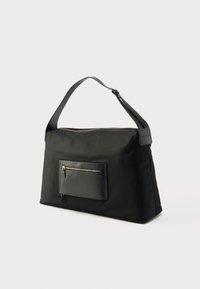 Μαύρη τσάντα ώμου από νάιλον, με μπροστινή τσέπη με φερμουάρ, λεία υφή και μακρύ, ρυθμιζόμενο ιμάντα. Λεπτομέρειες από χρυσό hardware σε διακριτικό στυλ.