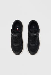 Scarpe da ginnastica nere in mesh e materiale sintetico, con colletto imbottito, lacci e una cinghia in velcro con il marchio "TOMMY HILFIGER".