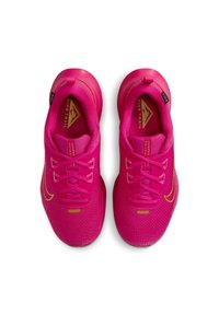 Zapatillas deportivas rosas con una parte superior de malla, que presentan un diseño texturizado, cordones en la parte delantera y acentos dorados en el logo y la marca.