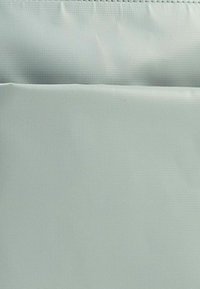 Helles Blau, strukturiertem Stoff mit glatter Oberfläche, abgerundetem oberen Teil und geraden Kanten. Keine sichtbaren Hardware oder Muster.
