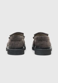 Scarpe in suede marrone con retro arrotondato, suole in gomma nera e dettagli di cucitura discreti, caratterizzate da un design a collo basso e hardware minimale.