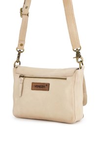 Hellbeige Lederhandtasche mit Reißverschluss, verstellbarem Riemen und einem Logoakzent aus braunem Leder. Glatte Textur, rechteckige Form.
