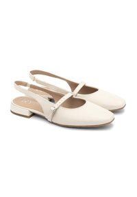 Krämfärgade slingback-skor med spetsig tå, platt klack och ankelrem med en liten spänndetalj. Slät läderstruktur.