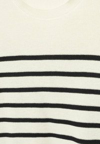 Pull en maille crème avec cinq rayures noires horizontales, uniformément espacées, sur la poitrine et le haut du torse.