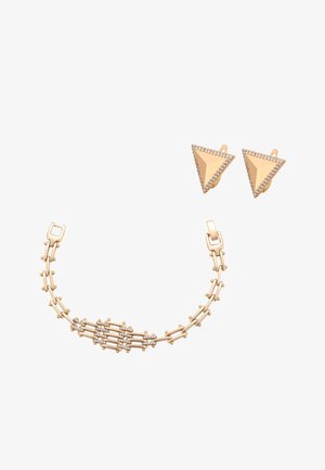 Złota bransoletka z połączonymi paskami i małymi diamentami połączona ze złotymi trójkątnymi kolczykami w kształcie sztyftów obramowanych diamentami.