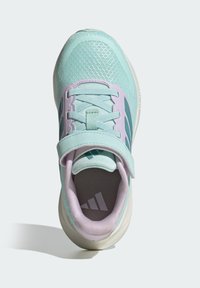 Svetlomodrá športová obuv so sieťovaným zvrškom, fialovými prvkami a pásikom na suchý zips. Má štruktúrovanú podrážku a logo na vnútornom vklade.