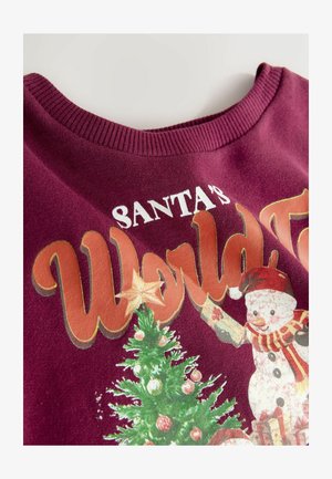 Kastanjefarvet sweater med rund hals, der har et festligt print af et juletre, en snemænd og teksten "Santa's World Tour" i livlige farver.