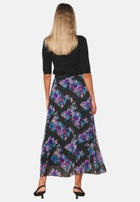 Maxi skirt featuring a black base with colorful floral patterns in purple and teal, pleated design, and a smooth waistband.
