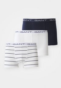 Trois paires de boxers pour hommes : un navy, un blanc, un blanc avec des rayures navy. Tissu doux, taille élastique avec logo "GANT".