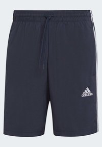 Námořnické modré sportovní šortky s elastickým pasem, šňůrkou, bočními pruhy a bílým logem Adidas na levé noze. Hladká textura.