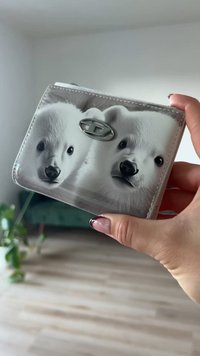 Portefeuille avec une finition brillante, orné d'un motif de deux oursons polaires, fermeture métallique, et de forme rectangulaire ; texture douce.