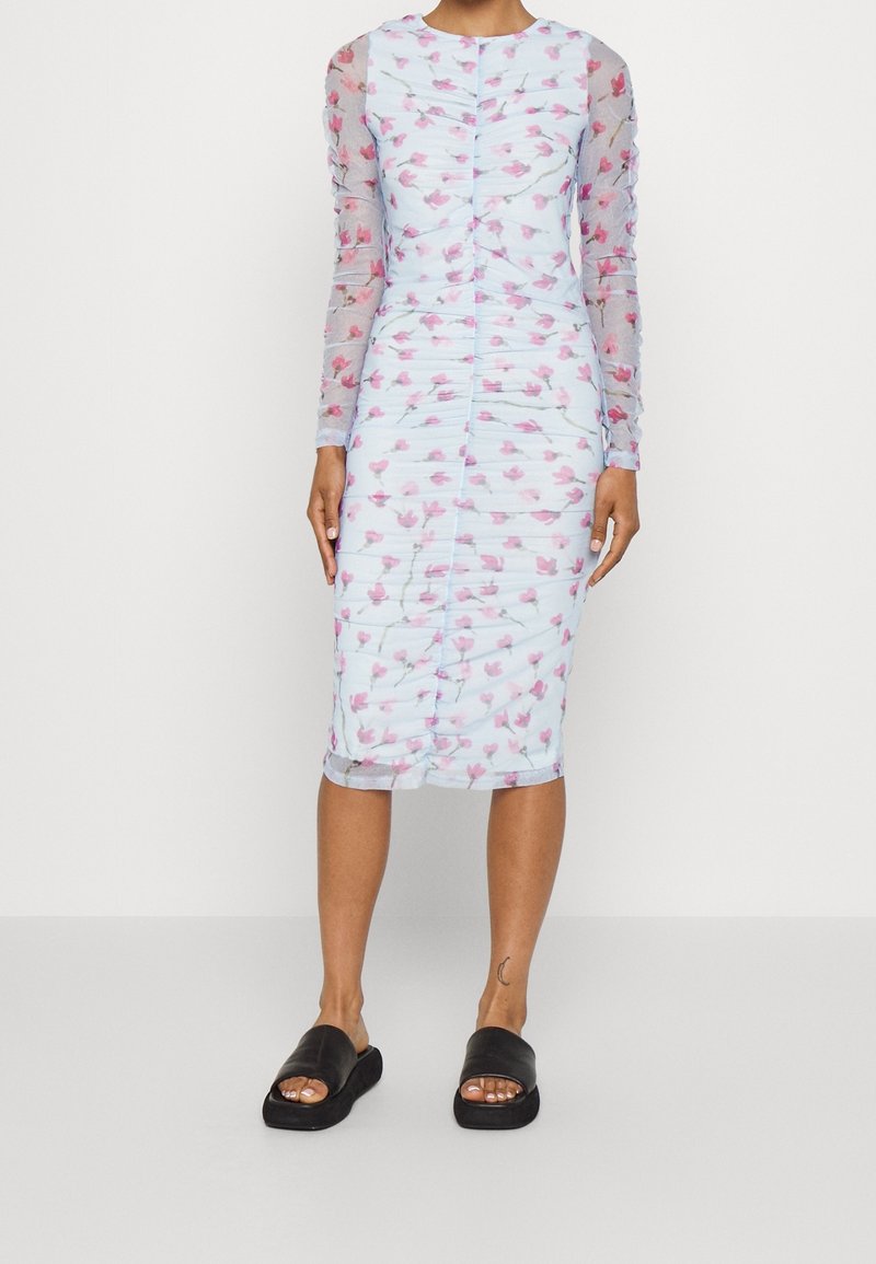 Lichtblauwe jurk met lange doorschijnende mouwen, voorzien van een bloemenpatroon in het roze. Ontworpen met een geplooide textuur en een getailleerde silhouet.