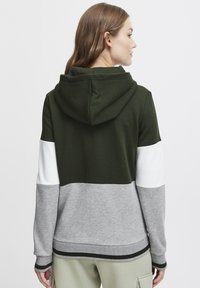 Hoodie med en färgblockdesign i mörkgrön, vit och grå. Tillverkad av mjukt tyg med ribbade mudd och fåll.