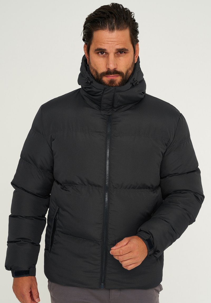 Schwarze Steppjacke mit hohem Kragen, Reißverschluss vorne und elastischen Bündchen. Verfügt über ein gestepptes Design und Seitentaschen. Hergestellt aus synthetischem Material.