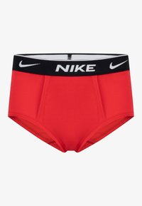 Červené športové slipy s čiernym pásom a bielym logom "NIKE". Hladká tkanina a priliehavý strih, vhodné na aktívne používanie.