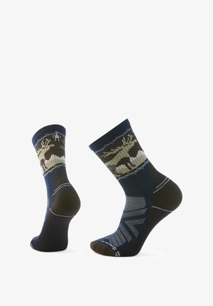 Calzini blu navy con finitura testurizzata, caratterizzati da un motivo forestale in tonalità terrose, con tallone e punta rinforzati, e strisce a contrasto sulla parte superiore.