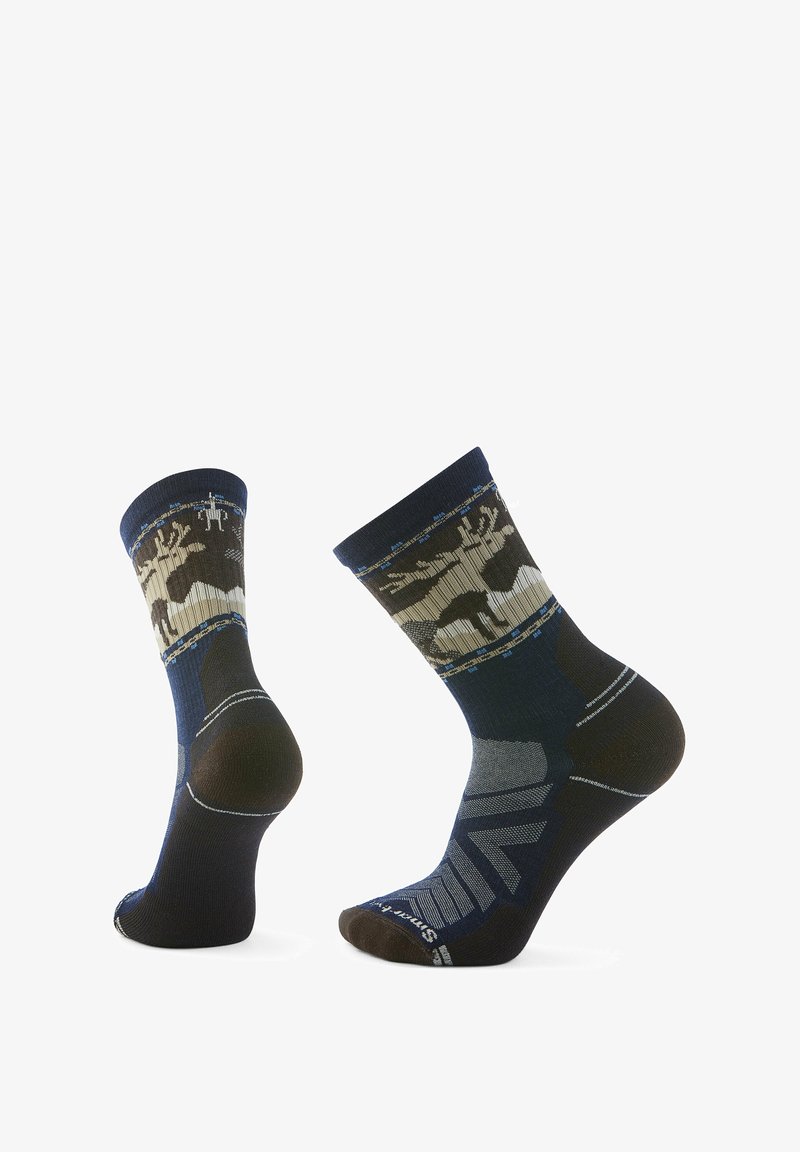 Navy socks with a textured finish featuring a forest pattern in earthy tones, reinforced heel and toe, and contrasting stripes on the upper.