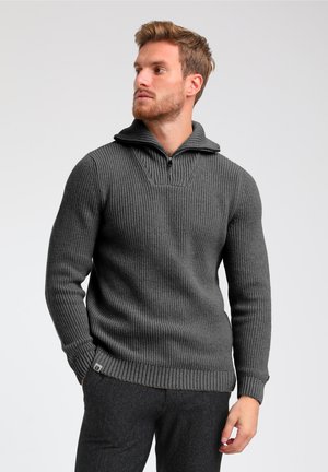 Dunkelgrauer gerippter Pullover mit hohem Kragen und kurzem Reißverschluss. Verfügt über eine strukturierte Oberfläche und enganliegende Ärmel. Auffälliger Saum mit gewebten Kanten.