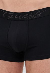 Svarte bomullsbokser med en elastisk midjebånd med mørk skrift. Glatt tekstur og tettsittende design for komfort.