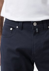 Mörkblå jeans i strukturerad bomull, med en traditionell femficksdesign, silverfärgad metalldetaljer och sydda detaljer vid midjan.