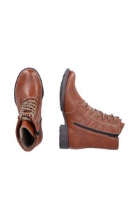 Braune Leder-Ankle-Boots mit Metallösen, dicken Schnürsenkeln und seitlichem Reißverschluss. Strukturiere Gummisohle für bessere Haftung. Runde Zehenform und gepolsterter Innenbereich.