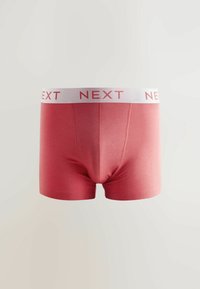 Rote Baumwoll-Boxershorts mit einem weißen Bund, auf dem das Logo "NEXT" in Pink gedruckt ist. Glatte Textur, enganliegendes Design und ohne sichtbare Muster.