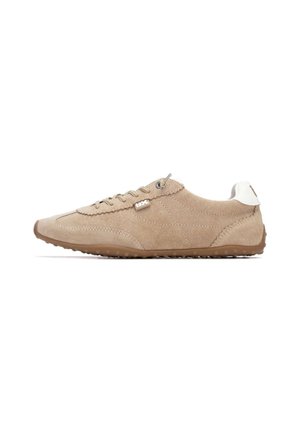 Zapatilla deportiva de ante beige con cierre de cordones, suela de goma y detalles texturizados. Presenta un pequeño logo en el lateral y una contrafuerte de talón en contraste.