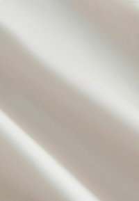 Cream-colored fabric with a smooth texture, displaying subtle sheen and light shadows, emphasizing flowing drapes and soft folds.