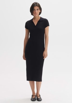 Abito midi nero a costine con maniche corte e collo. Presenta una silhouette aderente e un orlo dritto, realizzato in un tessuto elasticizzato.