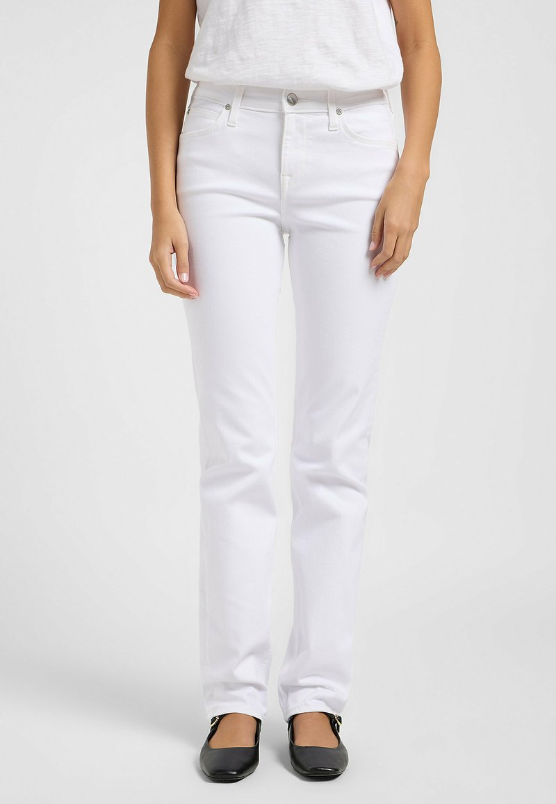 Jeans de mezclilla blanca de pierna recta con cinco bolsillos, cierre frontal de botones y una textura suave, combinados con bailarinas negras.