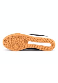 Suela de zapato negra con patrones circulares y hexagonales; material de goma naranja; franja blanca de acento; presenta textura para agarre.