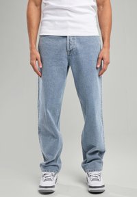 Jeans in denim blu chiaro con vestibilità rilassata, dotati di cinque tasche, passanti per cintura e leggere scoloriture nella parte anteriore.