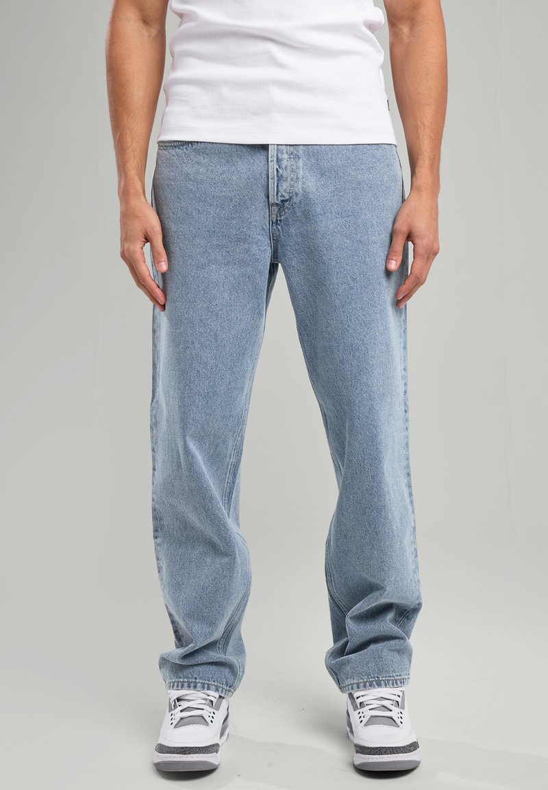 Jeans in denim blu chiaro con vestibilità rilassata, dotati di cinque tasche, passanti per cintura e leggere scoloriture nella parte anteriore.