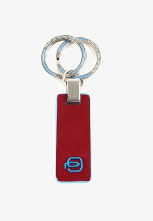 Llavero de cuero rojo con acentos azules, que presenta una forma rectangular y un clip de metal, adherido a dos anillos de acero inoxidable.