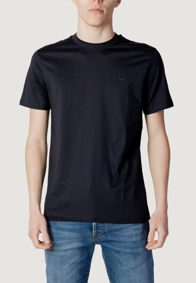 Sort bomulds T-shirt med rund hals og korte ærmer. Har et diskret logo på brystet. Glat tekstur og normal pasform.