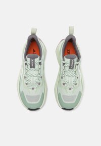 Baskets de sport vert clair avec un extérieur en mesh, des accents gris, des lacets texturés et une semelle en caoutchouc noire. La semelle intérieure est orange avec un logo.