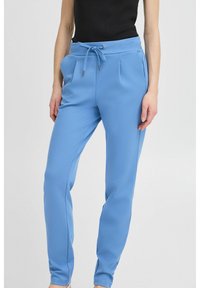 Pantalones jogger de color azul claro, confeccionados en tejido suave, con cintura elástica ajustable, bolsillos laterales y piernas ajustadas con puños elásticos.