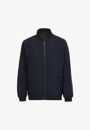 Námořnická modrá bombr jacket s vysokým límcem, předním zipem a bočními kapsami. Hladká tkanina s ribbovanými manžetami a lemem.