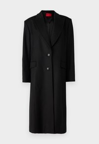 Sort uldblandet lang frakke med store klapper, to forlommer og en enkelt knaplukning. Indvendig har den et brandet foer.