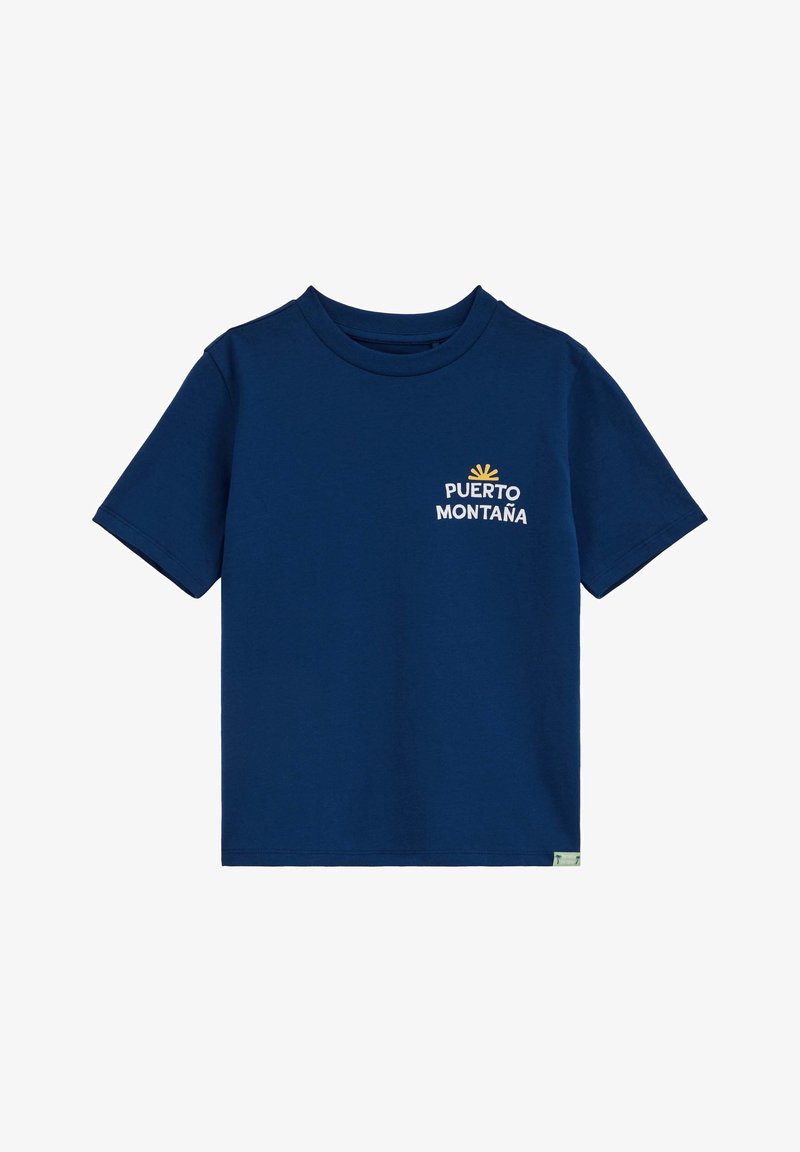 T-shirt en coton bleu foncé à manches courtes avec col rond, affichant le texte blanc "PUERTO MONTAÑA" et un petit graphisme de soleil jaune sur la poitrine gauche.