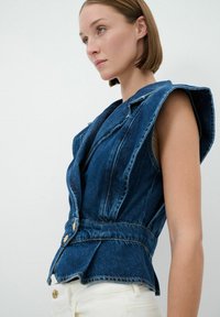 Gilet in denim con spalle strutturate, vita aderente e dettagli con bottoni dorati. Colore blu intenso, texture liscia e cuciture dettagliate.