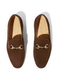 Bruine suède loafers met een ronde neus, gouden harnasdetail en tonale stiksels. Glad leren interieur en een lage zool.