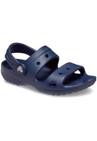 Mørkeblå plastsandaler med to brede stropper og ventilasjonshull. Har teksturert såle og et rundt logo på siden.