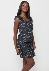 Abito blu navy con scollo arricciato, maniche corte e gonna a strati, caratterizzato da piccoli motivi floreali dorati su uno sfondo scuro.