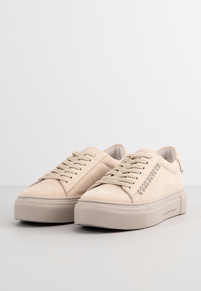 Beige Wildlederschuhe mit einer strukturierten Gummisohle, versehen mit einem Schnürdesign und einem dekorativen Strassakzent an der Seite.
