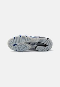 Suola di scarpe da corsa con un motivo di trazione bianco e accenti blu e neri, progettata per garantire aderenza e stabilità durante l'uso.