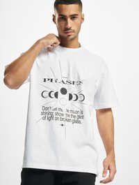 Hvid bomulds T-shirt med et trykt grafisk design af månephaser og tekst i sort. Løs pasform med korte ærmer og rund halsudskæring.