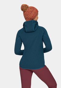 Niebieska bluza z długim rękawem o dopasowanym kroju, teksturowany materiał i kaptur. W zestawie z bordowymi spodniami. Kolorowa dziana czapka z pomponem.